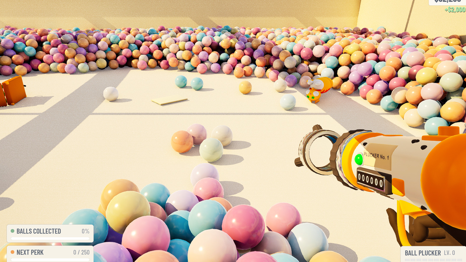 The Ball Plucker No. 1, a cream and orange barrel with a green indicator light, held over cleared ball pit floor.